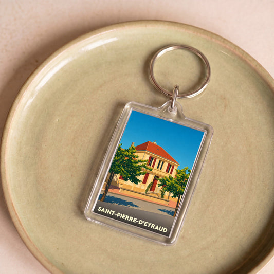 Porte-clés souvenir de la ville de Saint-Pierre-d'Eyraud avec une illustration stylisée d'un bâtiment remarquable.