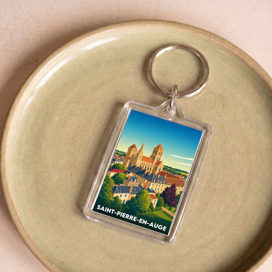 Porte-clés souvenir de la ville de Saint-Pierre-en-Auge avec une illustration stylisée.