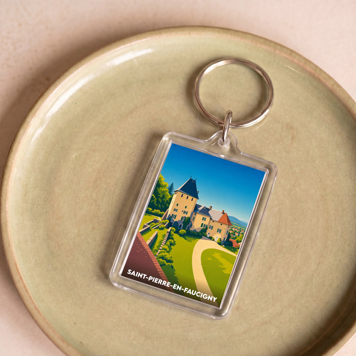 Porte-clés souvenir de la ville de Saint-Pierre-en-Faucigny avec une illustration stylisée d'un château.