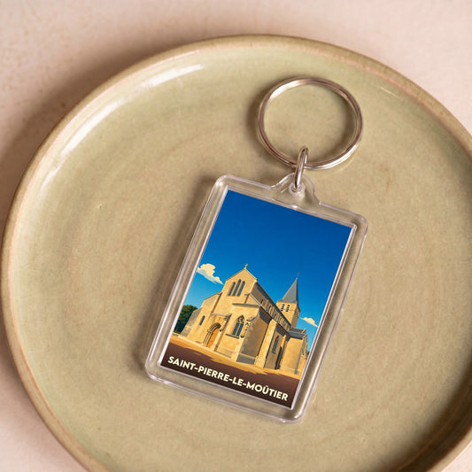 Porte-clés souvenir de la ville de Saint-Pierre-le-Moûtier avec une illustration stylisée de son église.