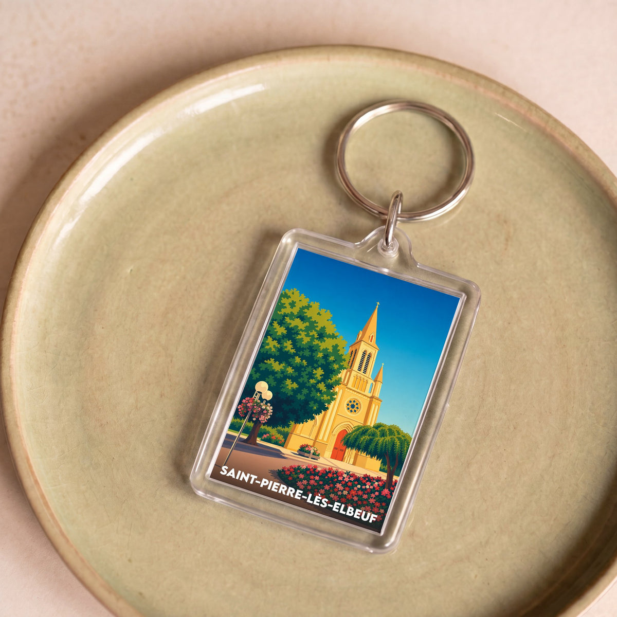 Porte-clés souvenir de la ville de Saint-Pierre-lès-Elbeuf avec une illustration stylisée de son église.