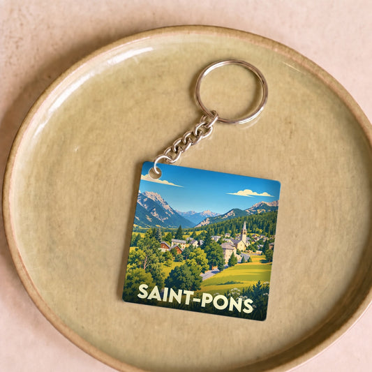 Porte-clés souvenir de la ville de Saint-Pons avec une illustration stylisée d'un paysage montagneux.