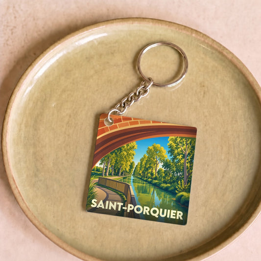 Porte-clés souvenir de la ville de Saint-Porquier avec une illustration stylisée d'un canal sous un pont.