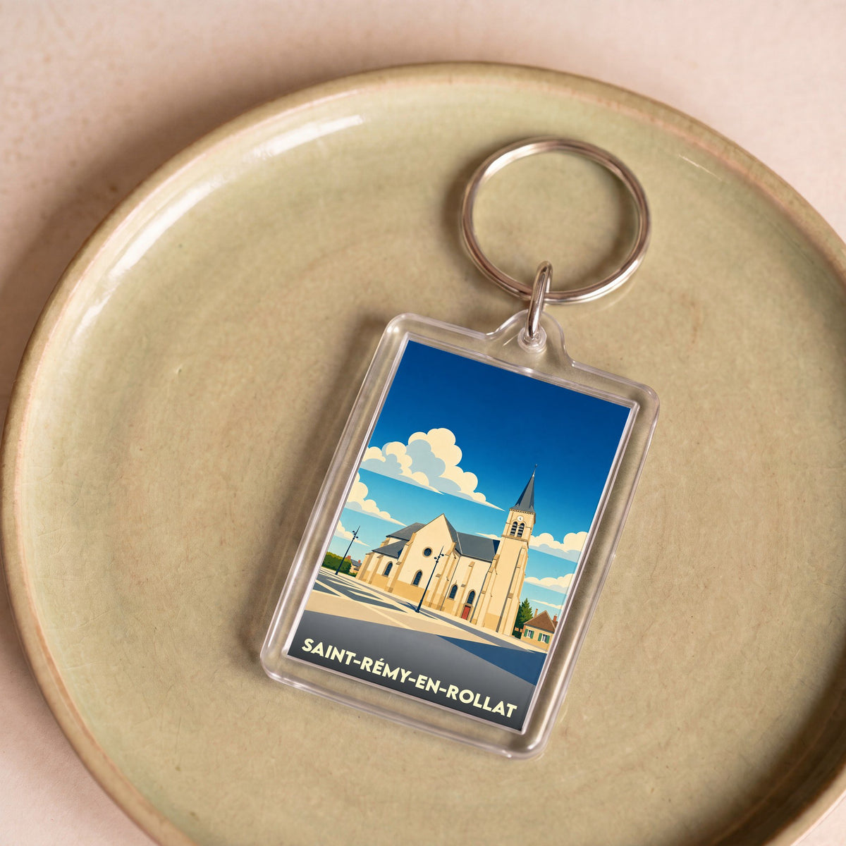 Porte-clés souvenir de la ville de Saint-Rémy-en-Rollat avec une illustration stylisée de son église.