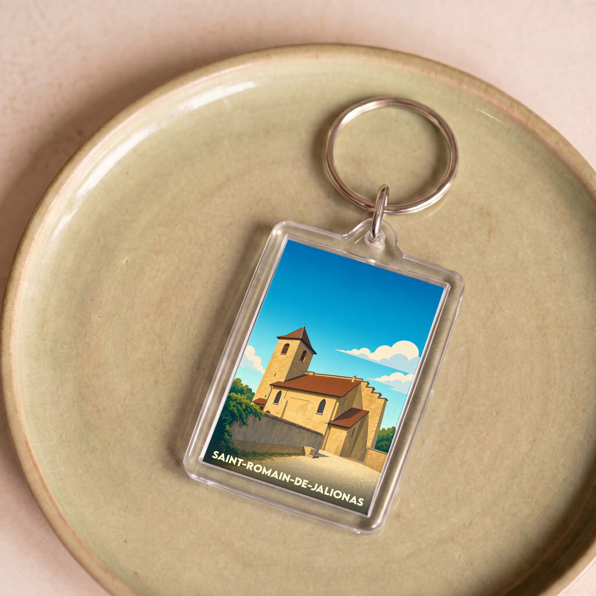 Porte-clés souvenir de la ville de Saint-Romain-de-Jalionas avec une illustration stylisée de son église.