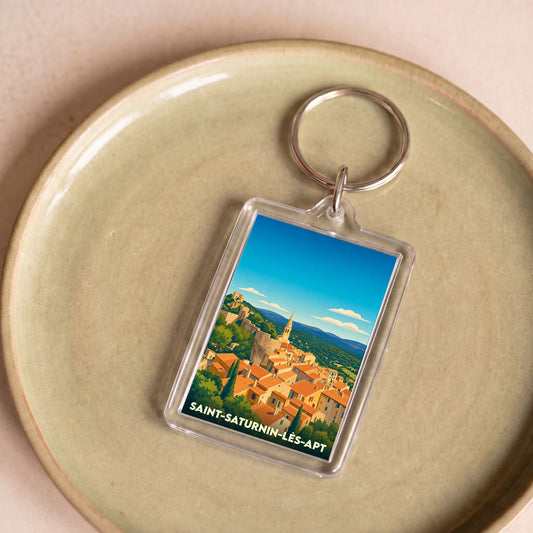 Porte-clés souvenir de la ville de Saint-Saturnin-lès-Apt avec une illustration stylisée.