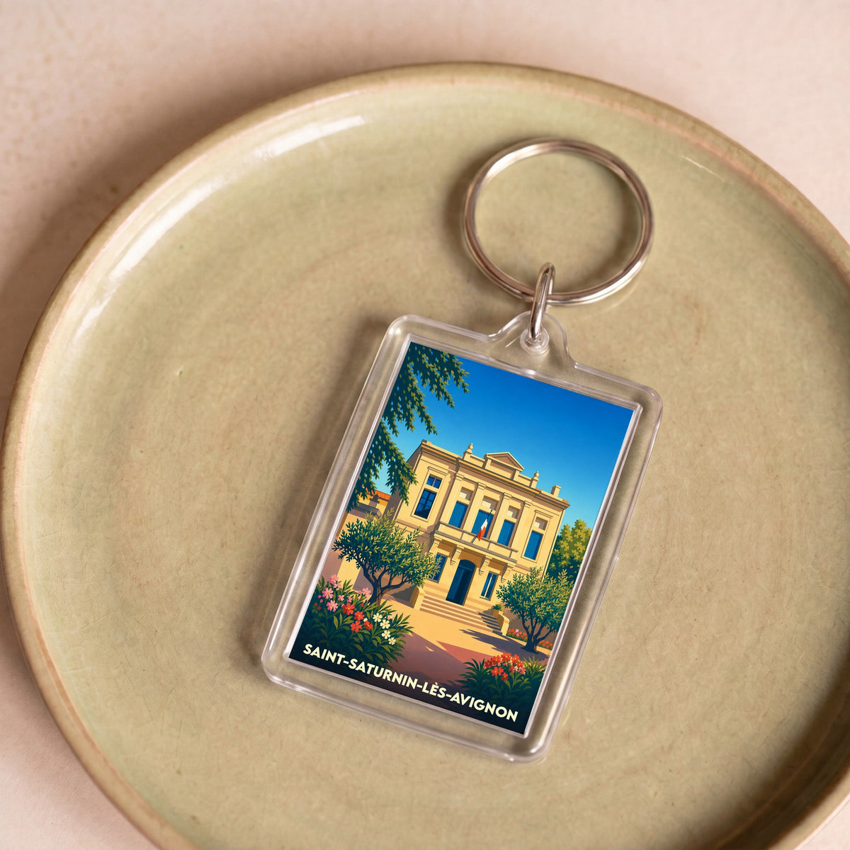 Porte-clés souvenir de la ville de Saint-Saturnin-lès-Avignon avec une illustration stylisée de sa mairie.