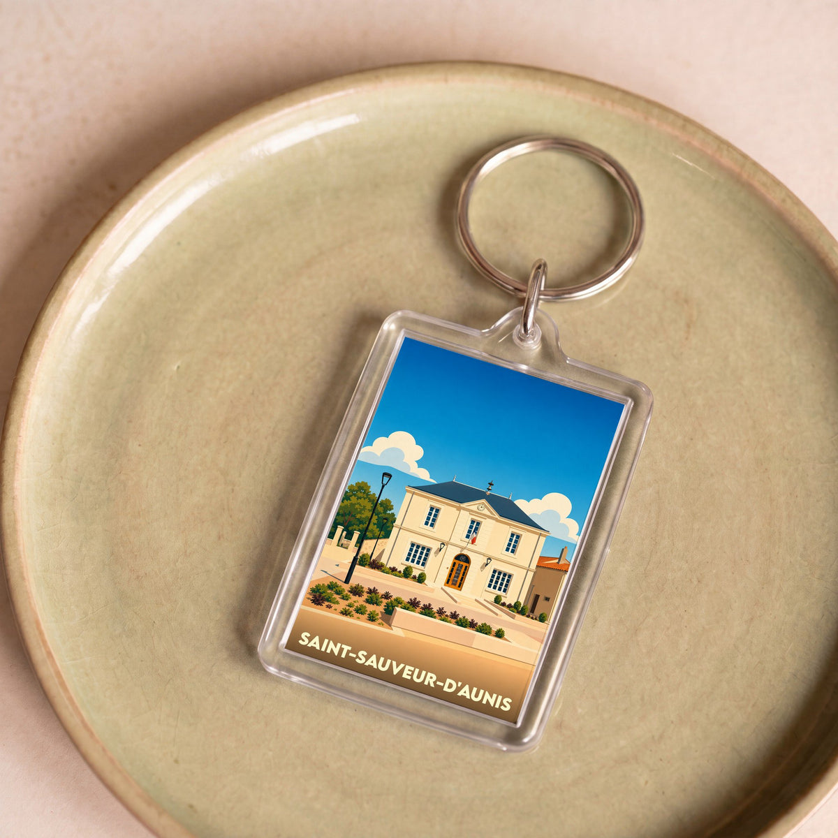 Porte-clés souvenir de la ville de Saint-Sauveur-d'Aunis avec une illustration stylisée de sa mairie.