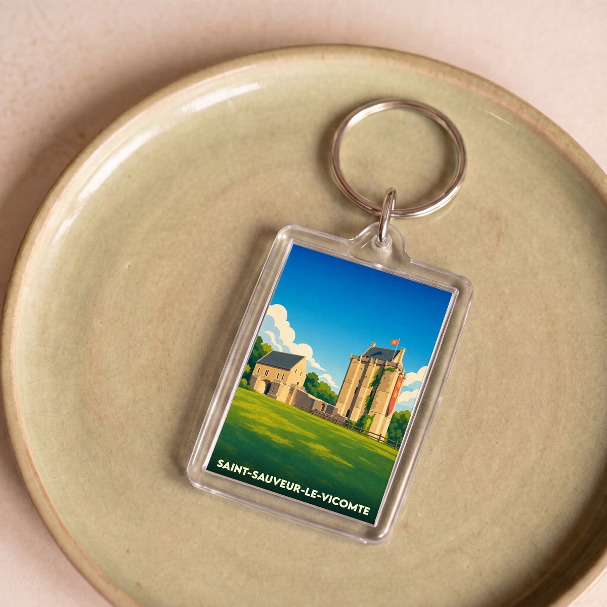 Porte-clés souvenir de la ville de Saint-Sauveur-le-Vicomte avec une illustration stylisée de son château.