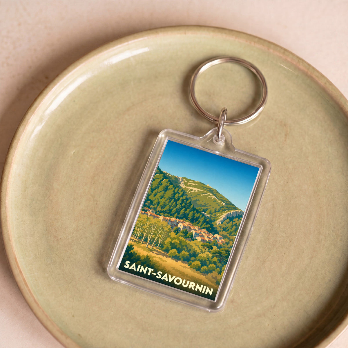 Porte-clés souvenir de la ville de Saint-Savournin avec une illustration stylisée.