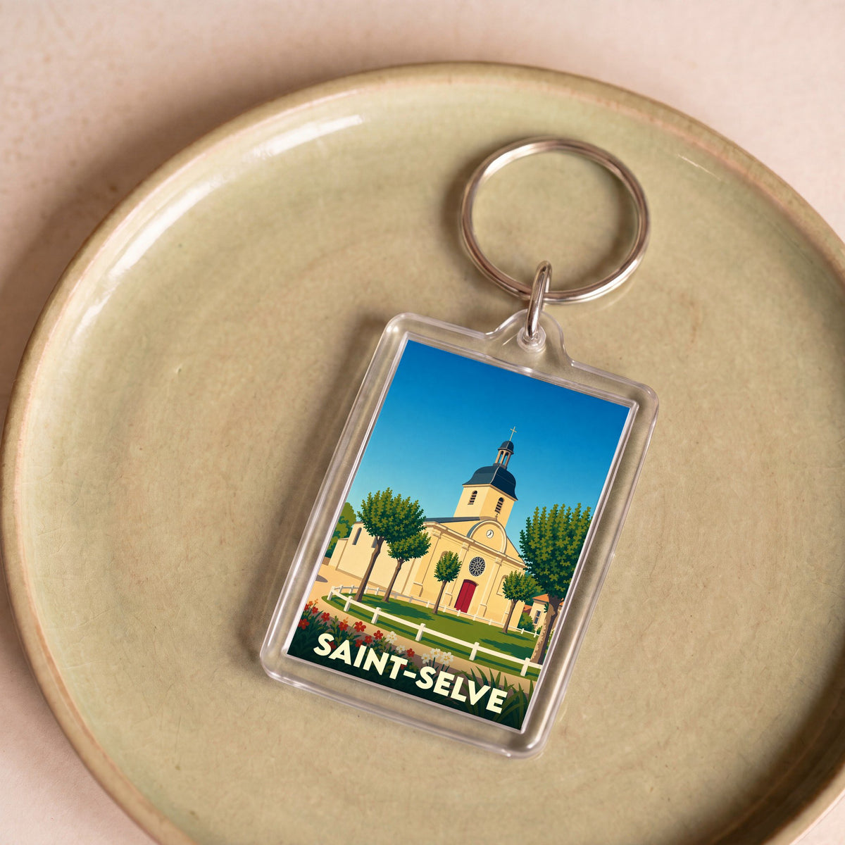 Porte-clés souvenir de la ville de Saint-Selve avec une illustration stylisée de son église.