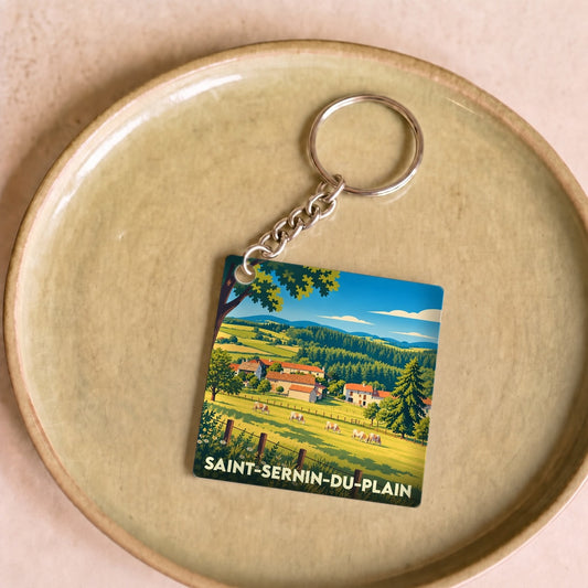Porte-clés souvenir de Saint-Sernin-du-Plain avec une illustration stylisée d'un paysage rural.