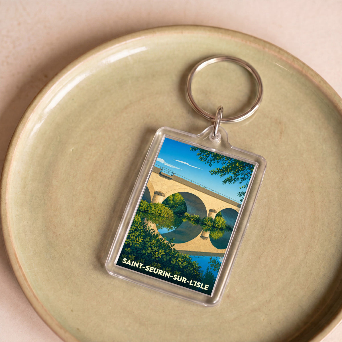 Porte-clés souvenir de la ville de Saint-Seurin-sur-l'Isle avec une illustration stylisée de son pont.