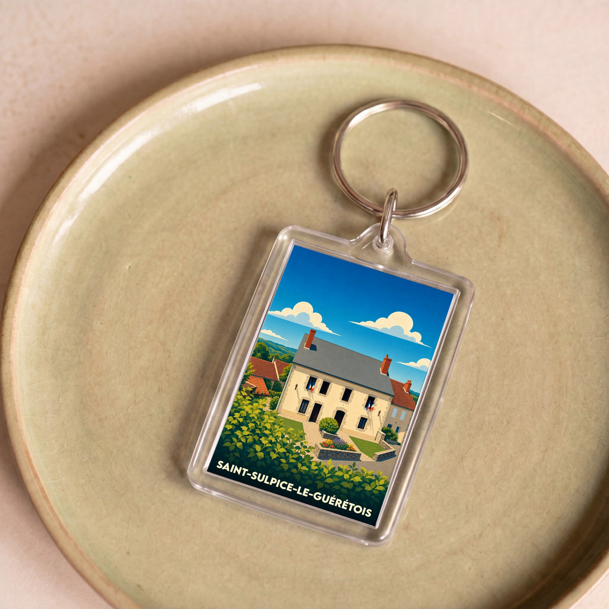 Porte-clés souvenir de la ville de Saint-Sulpice-le-Guérétois avec une illustration stylisée de la mairie.