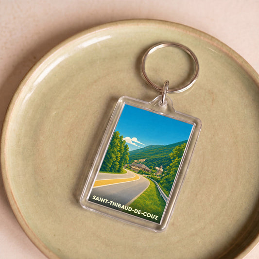 Porte-clés souvenir de la ville de Saint-Thibaud-de-Couz avec une illustration stylisée d'un paysage montagneux.