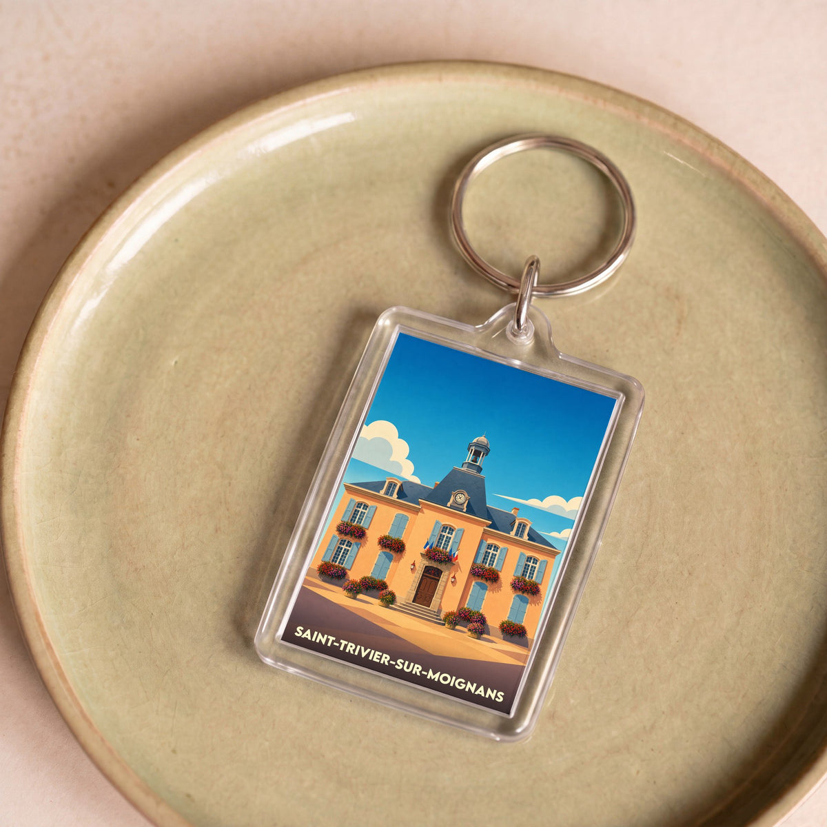 Porte-clés souvenir de la ville de Saint-Trivier-sur-Moignans avec une illustration stylisée de sa mairie.