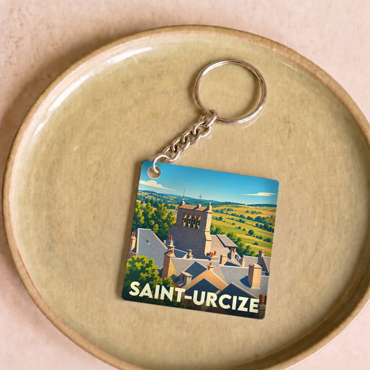 Porte-clés souvenir de la ville de Saint-Urcize illustré d'une vue stylisée de ses toits et de son église.