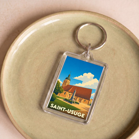 Porte-clés souvenir de la ville de Saint-Usuge avec une illustration stylisée.