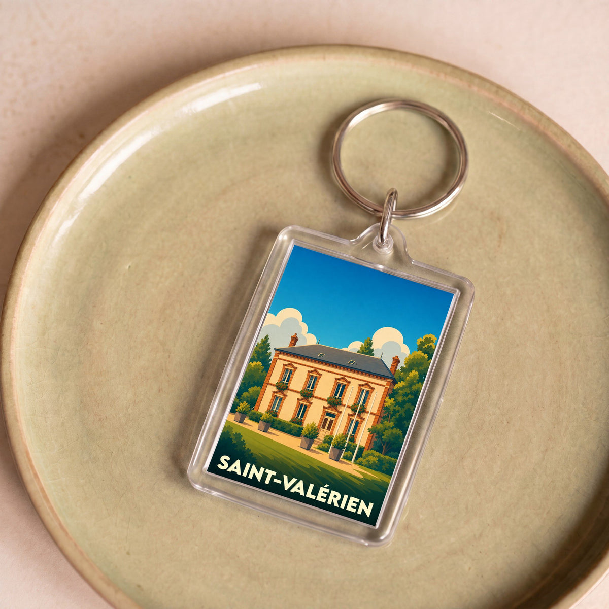 Porte-clés souvenir de la ville de Saint-Valérien avec une illustration stylisée d'une demeure bourgeoise.