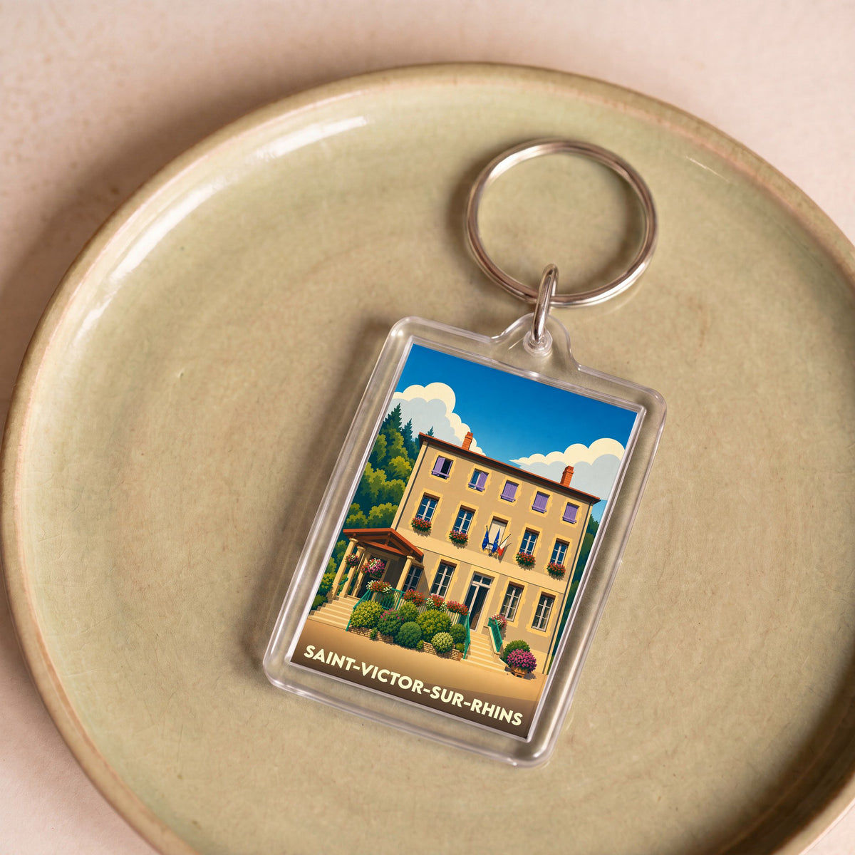 Porte-clés souvenir de la ville de Saint-Victor-sur-Rhins avec une illustration stylisée.