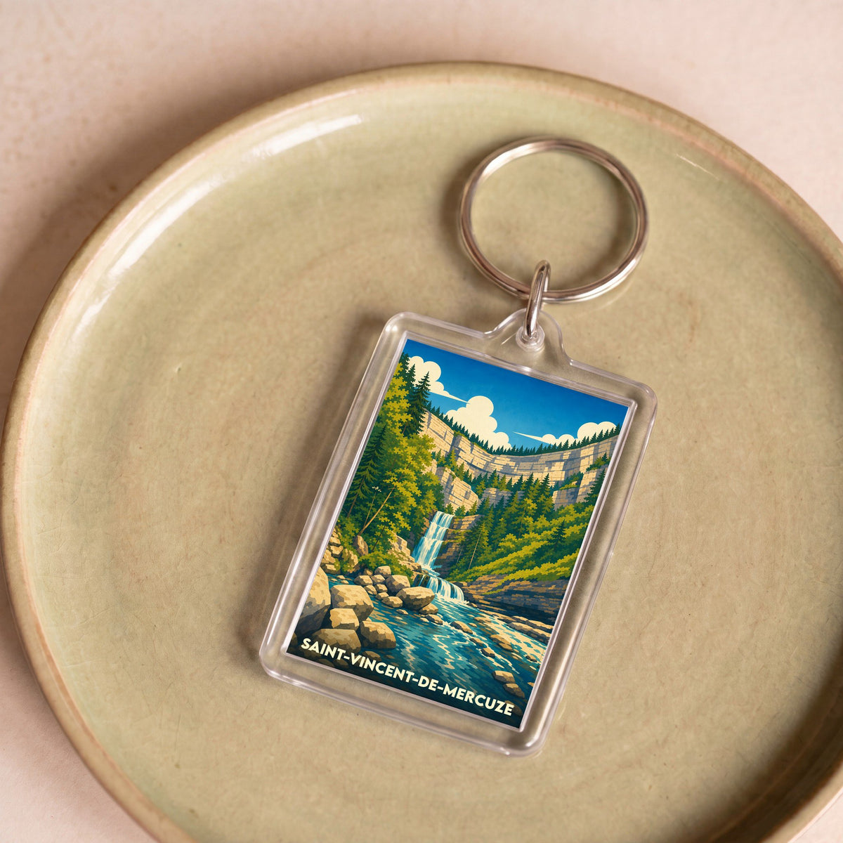 Porte-clés souvenir de la ville de Saint-Vincent-de-Mercuze avec une illustration stylisée d'une cascade.