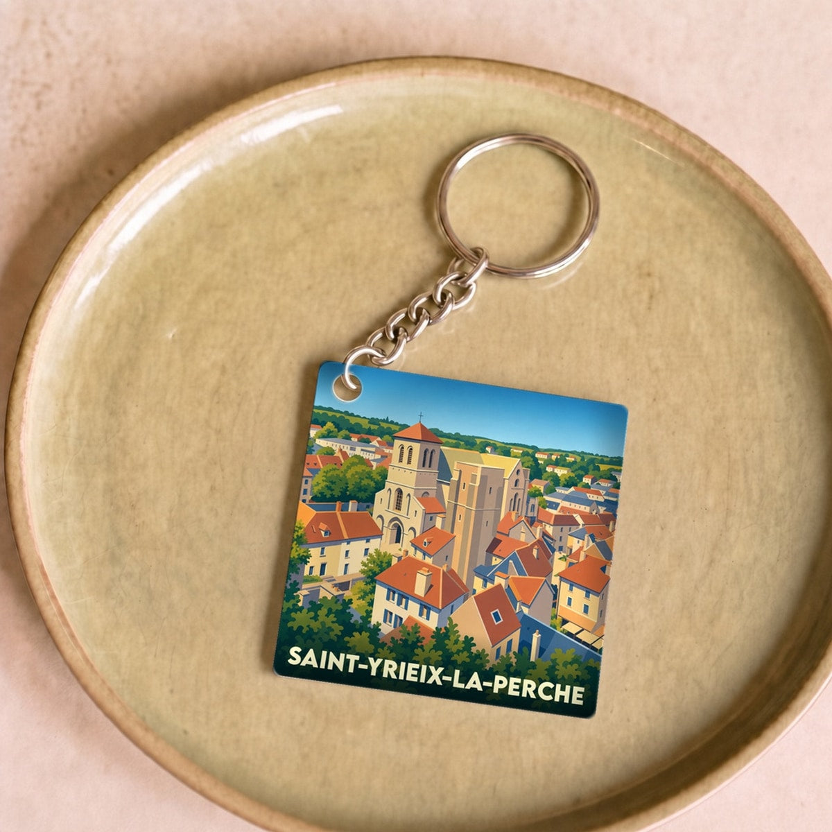 Porte-clés souvenir de la ville de Saint-Yrieix-la-Perche avec une illustration stylisée.
