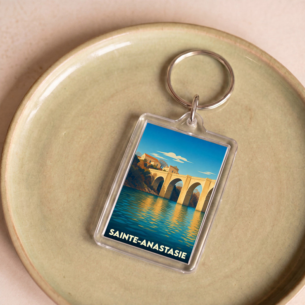 Porte-clés souvenir de la ville de Sainte-Anastasie avec une illustration stylisée d'un pont de pierre.
