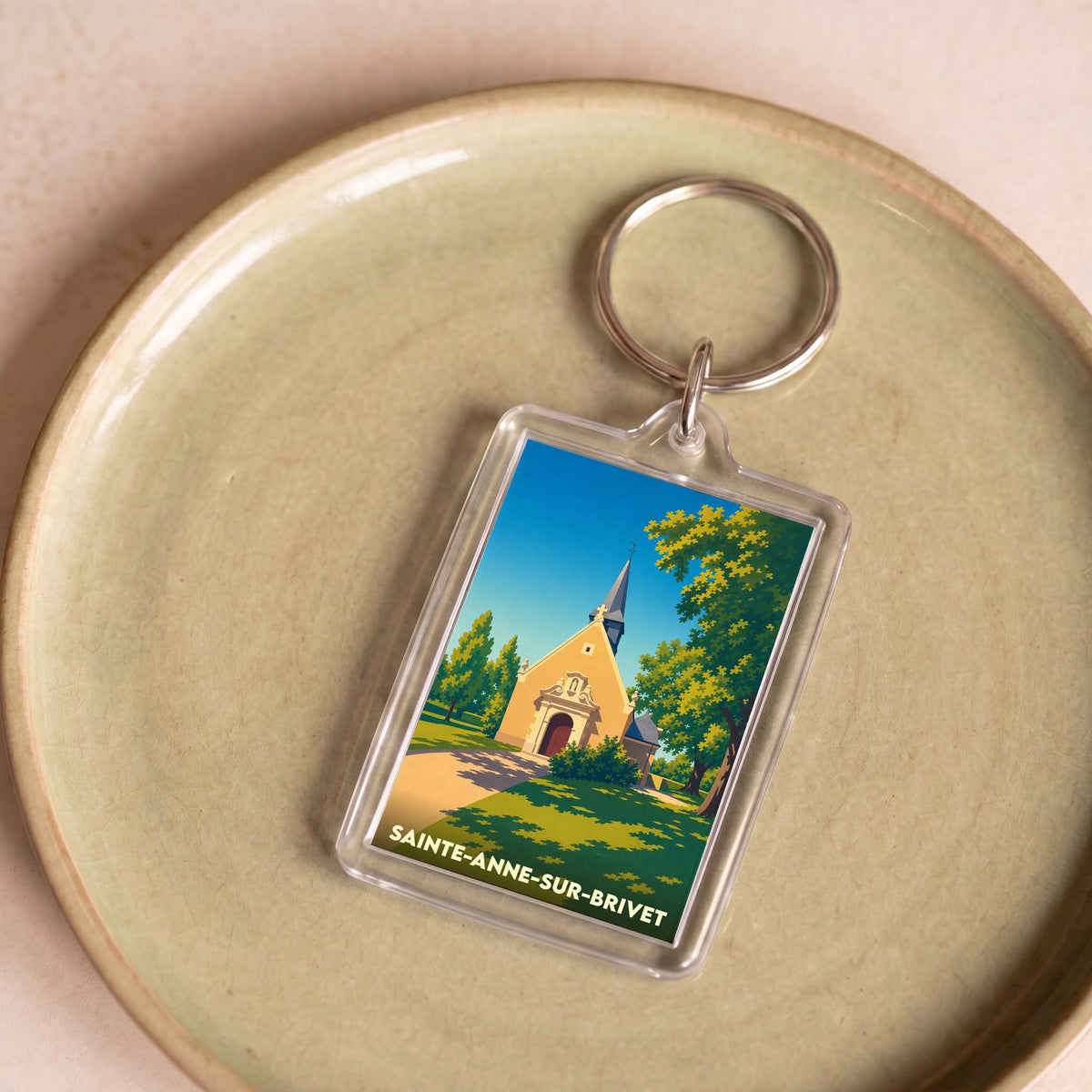 Porte-clés souvenir de la ville de Sainte-Anne-sur-Brivet avec une illustration stylisée de sa chapelle.