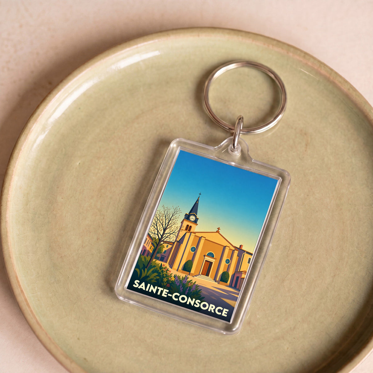 Porte-clés souvenir de la ville de Sainte-Consorce avec une illustration stylisée de son église.