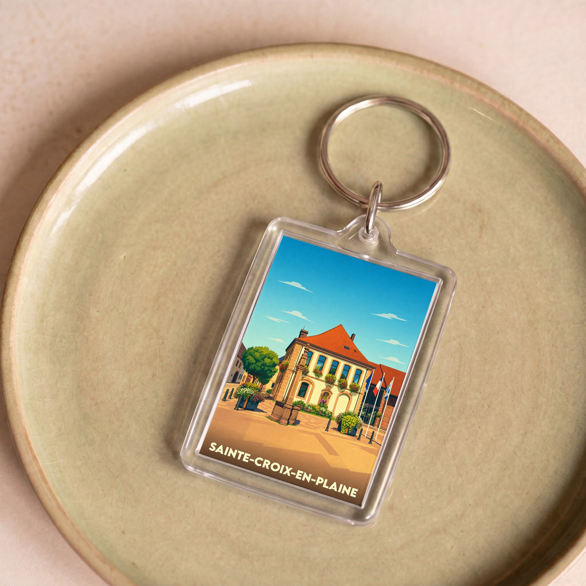 Porte-clés souvenir de la ville de Sainte-Croix-en-Plaine avec une illustration stylisée.
