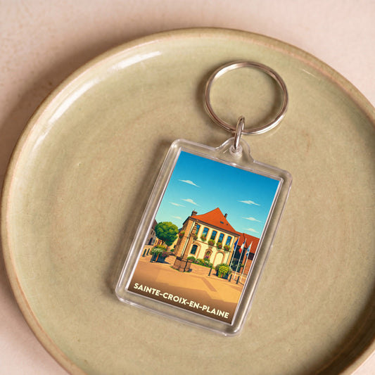 Porte-clés souvenir de la ville de Sainte-Croix-en-Plaine avec une illustration stylisée.