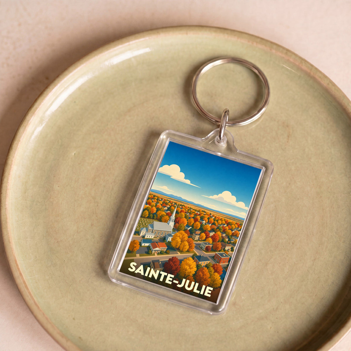 Porte-clés souvenir de la ville de Sainte-Julie avec une illustration automnale stylisée.
