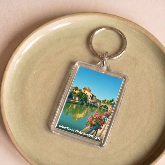 Porte-clés souvenir de la ville de Sainte-Livrade-sur-Lot avec une illustration stylisée.