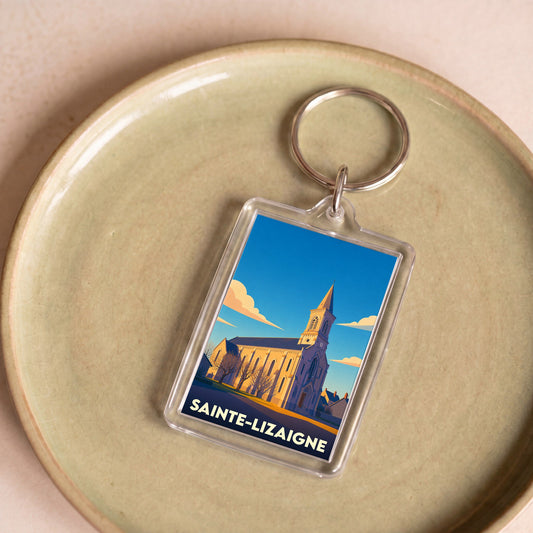 Porte-clés souvenir de la ville de Sainte-Lizaigne avec une illustration stylisée de son église sous un ciel bleu.