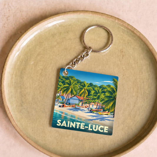 Porte-clés souvenir de la ville de Sainte-Luce avec une illustration stylisée d'une plage tropicale.