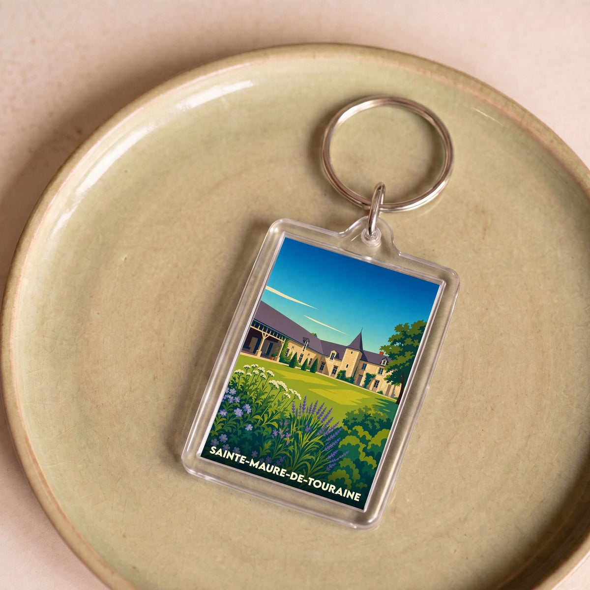 Porte-clés souvenir de la ville de Sainte-Maure-de-Touraine avec une illustration stylisée.