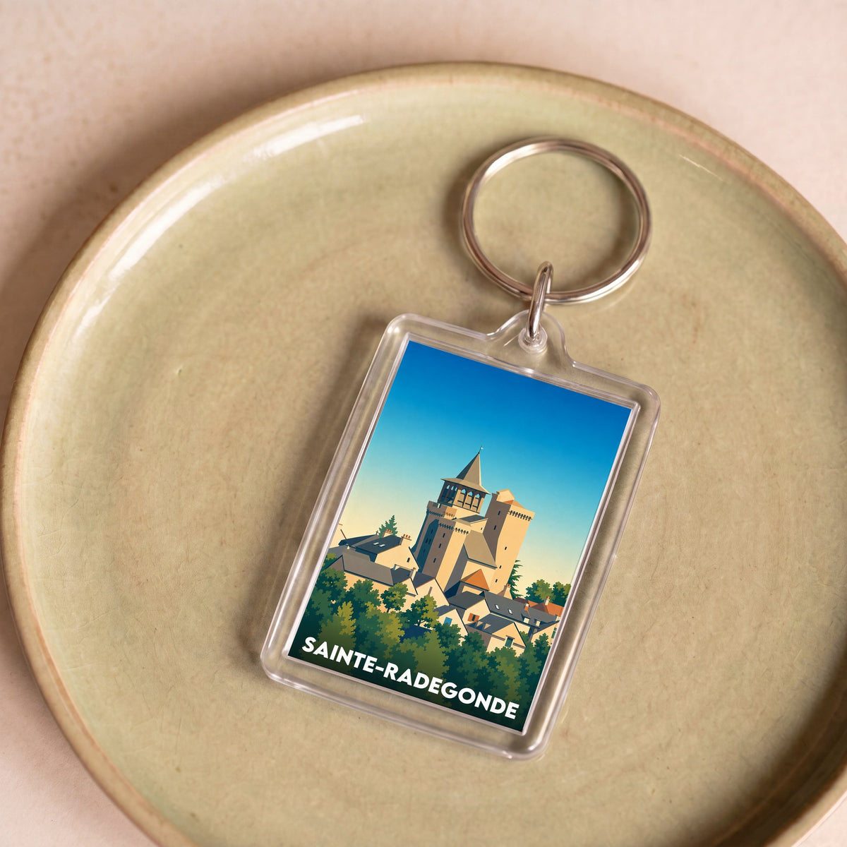 Porte-clés souvenir de la ville de Sainte-Radegonde avec une illustration stylisée.