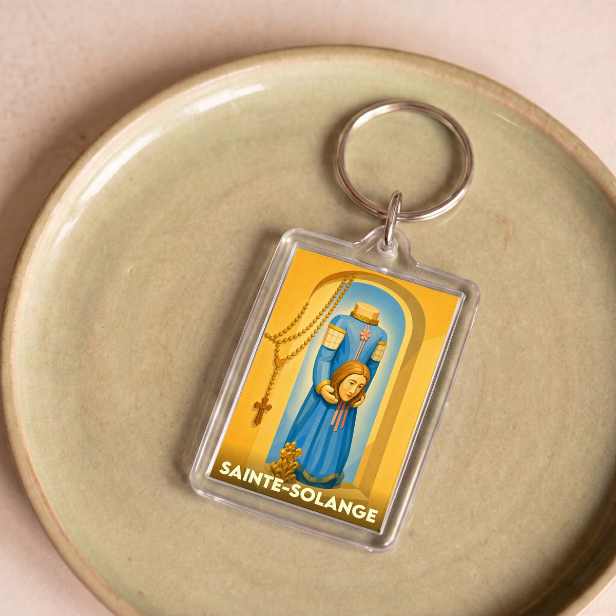 Porte-clés souvenir de la ville de Sainte-Solange illustrant la sainte patronne.
