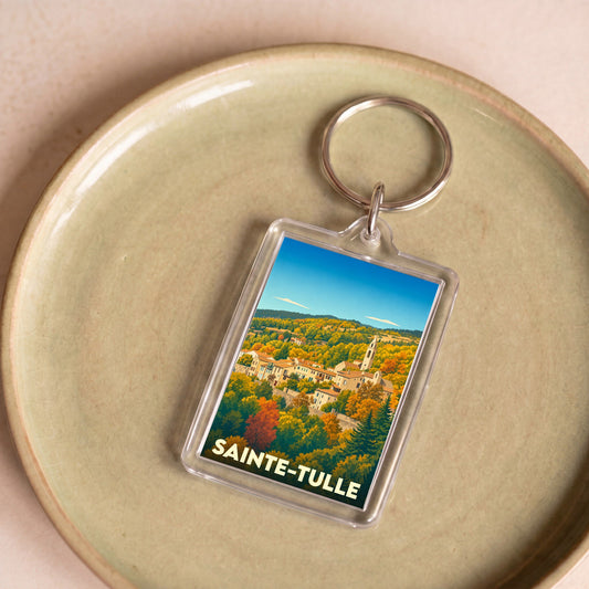 Porte-clés souvenir de la ville de Sainte-Tulle avec une illustration stylisée de son paysage vallonné.