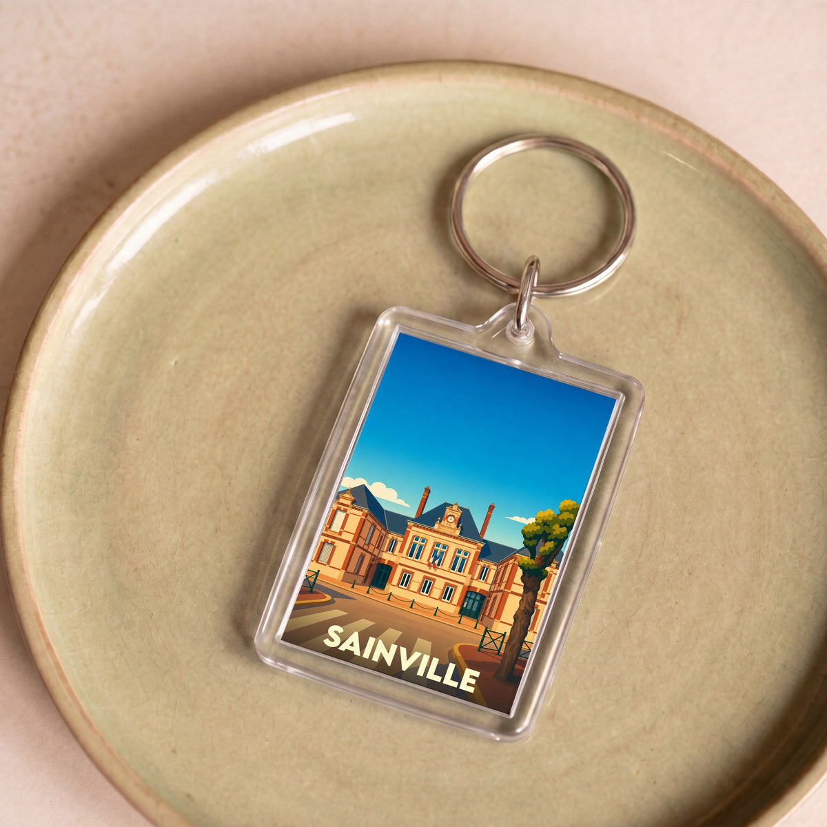 Porte-clés souvenir de la ville de Sainville avec une illustration stylisée.