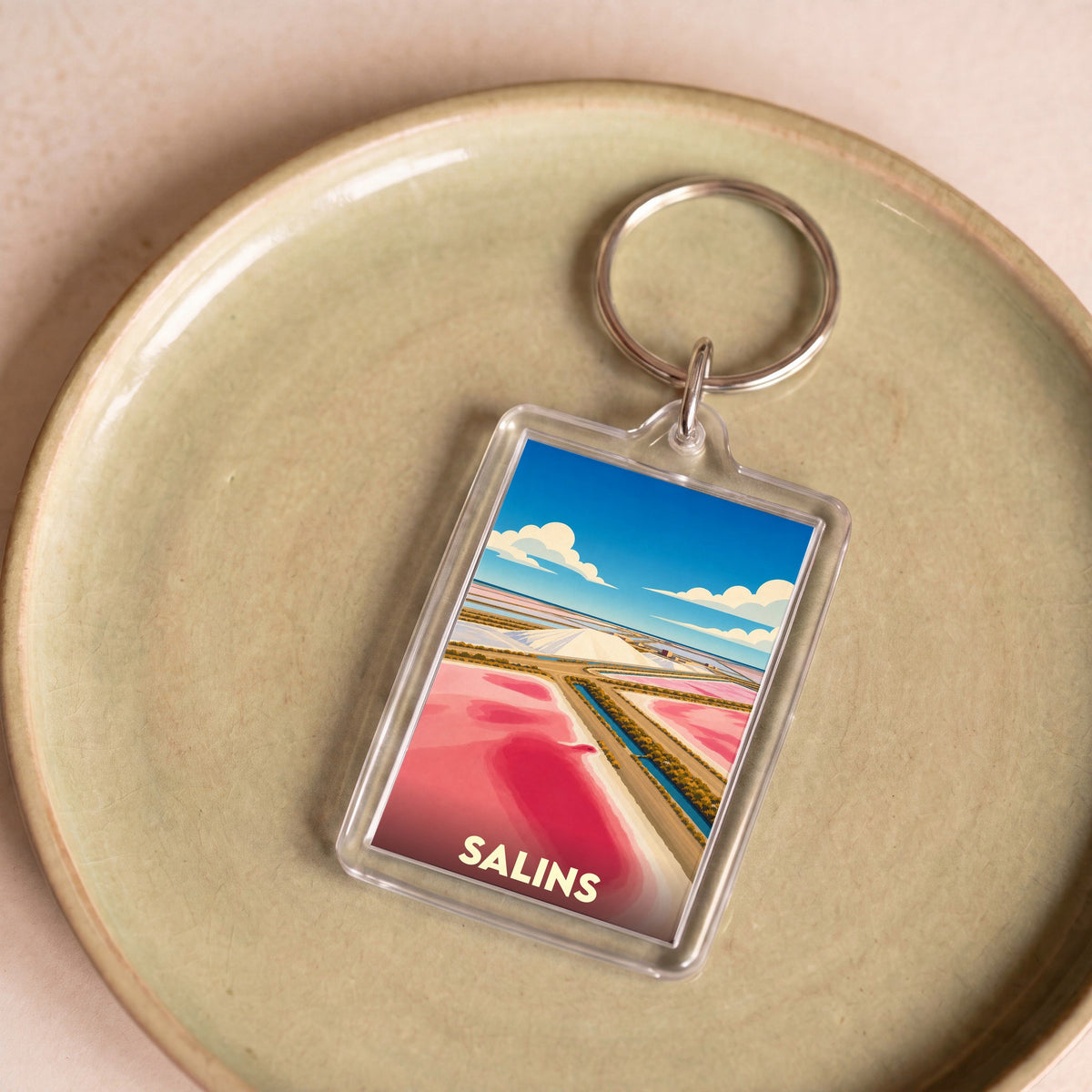 Porte-clés souvenir de la ville de Salins avec une illustration stylisée de ses marais salants colorés.