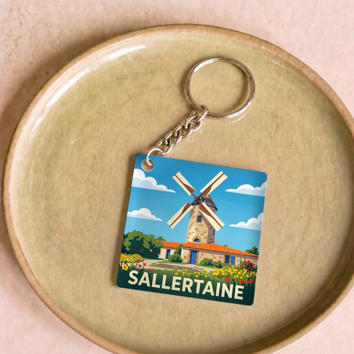 Porte-clés souvenir de la ville de Sallertaine avec une illustration stylisée d'un moulin.