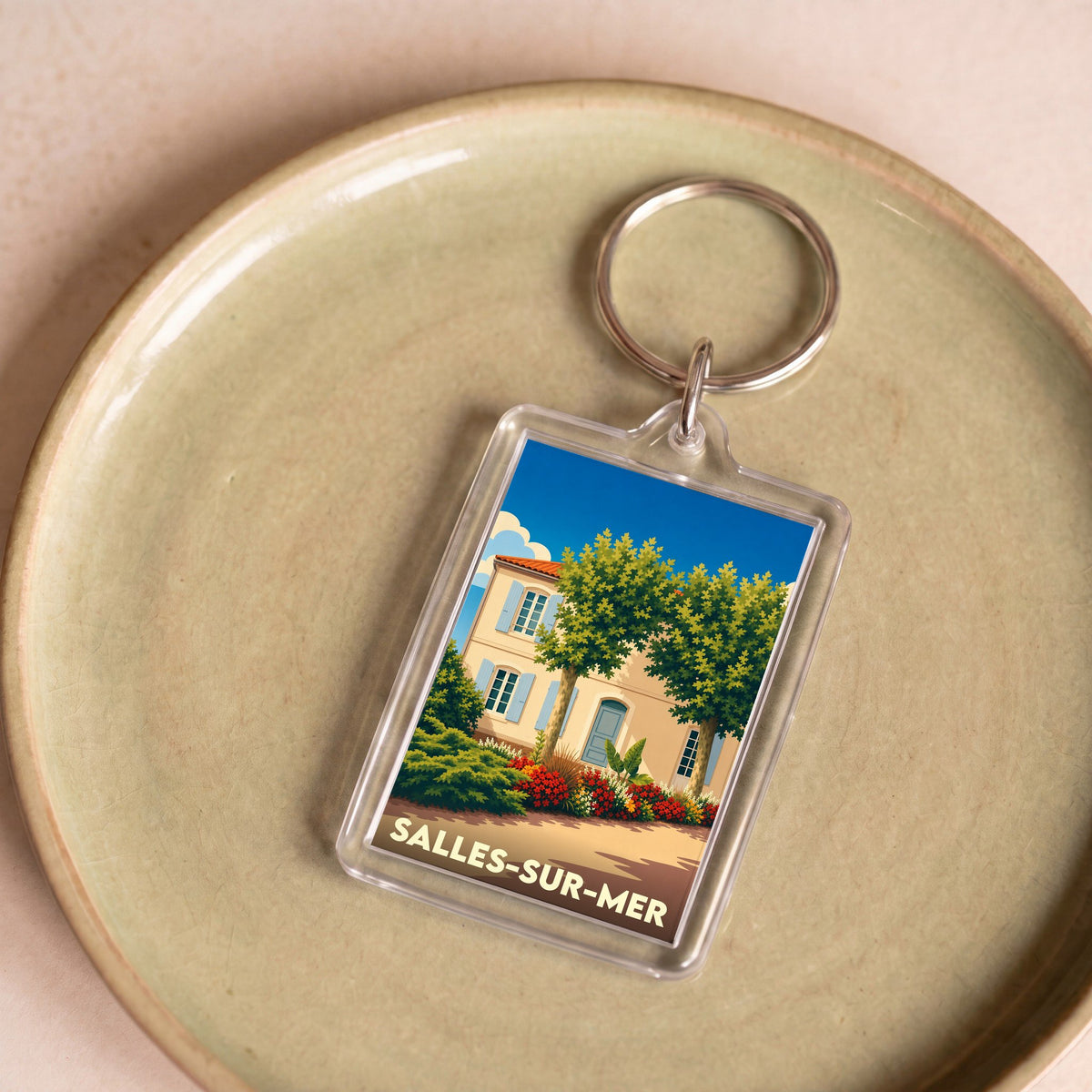 Porte-clés souvenir de la ville de Salles-sur-Mer avec une illustration stylisée.