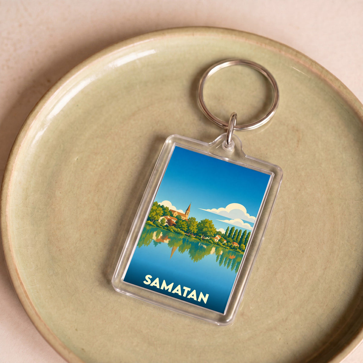 Porte-clés souvenir de la ville de Samatan avec une illustration stylisée des bords du lac.