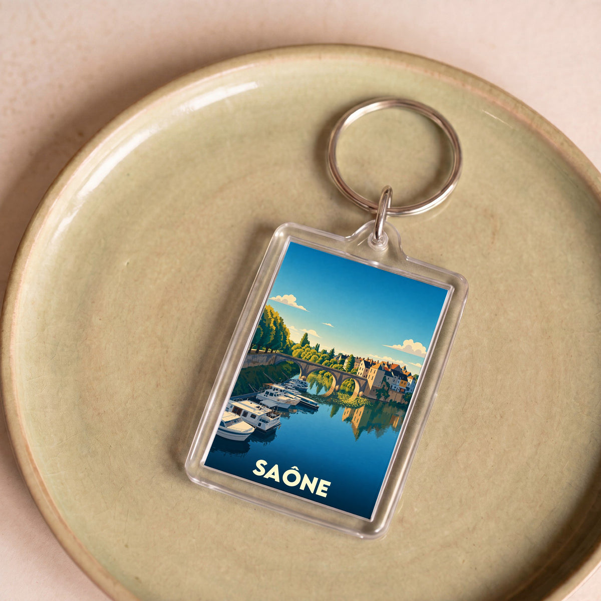 Porte-clés souvenir de la ville de Saône avec une illustration stylisée.