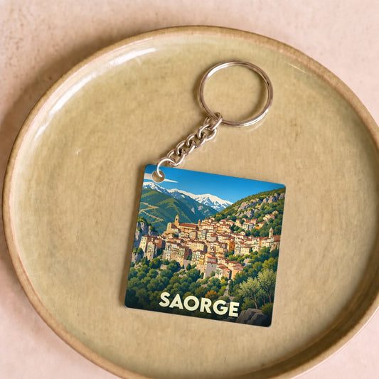 Porte-clés souvenir de la ville de Saorge avec une illustration stylisée du village de montagne.