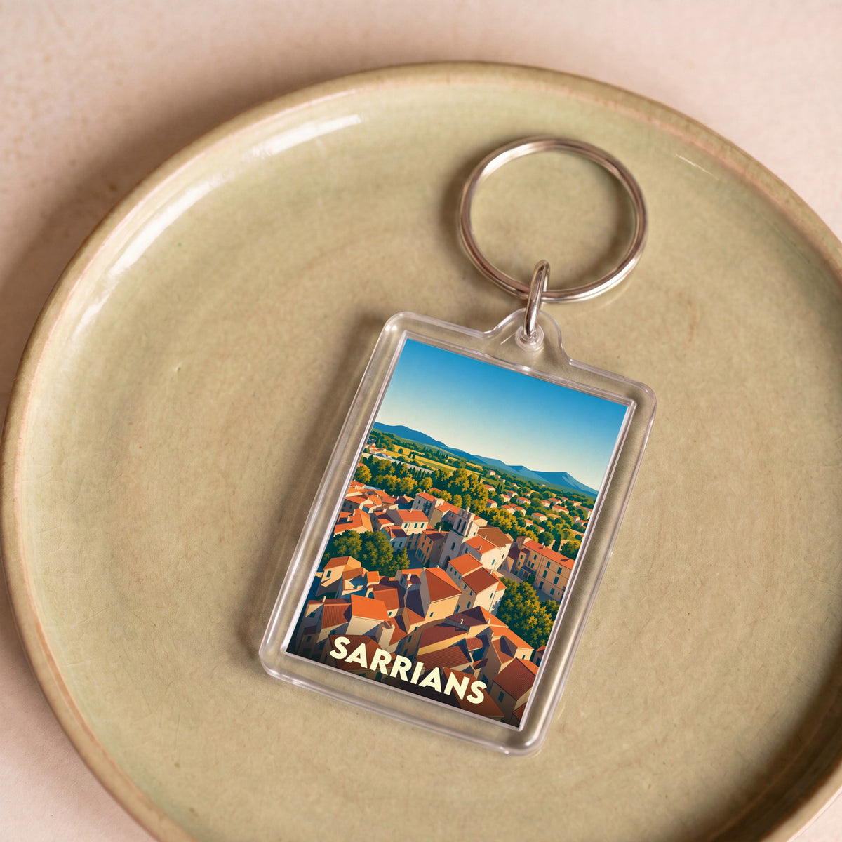 Porte-clés souvenir de la ville de Sarrians avec une illustration stylisée.