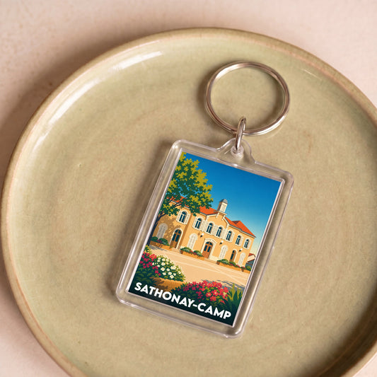 Porte-clés souvenir de la ville de Sathonay-Camp avec une illustration stylisée de sa mairie.