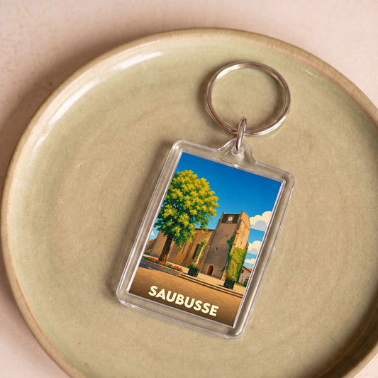 Porte-clés souvenir de la ville de Saubusse avec une illustration stylisée de son église.