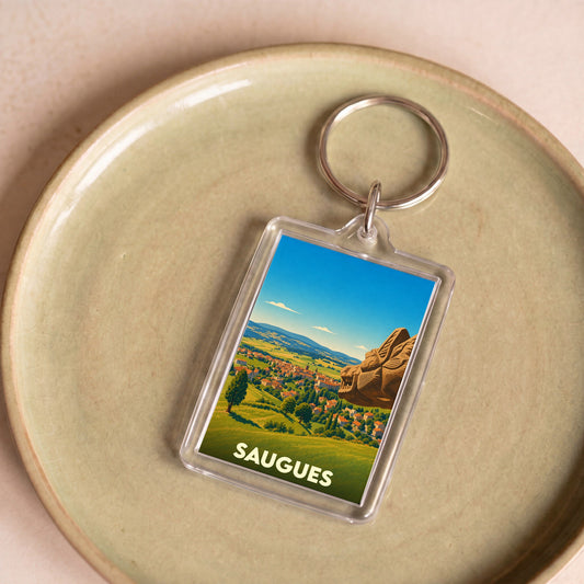 Porte-clés souvenir de la ville de Saugues avec une illustration stylisée.